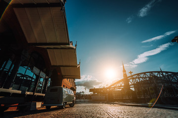 Beautiful retro style car packed on the cobbled square. Arch bridge over canals with Sankt...