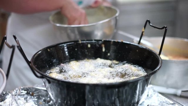 Putting cut squids in dough on hot oil in the restaurant kitchen
