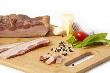Smoked pork bacon slab - on cutting board with vegetables