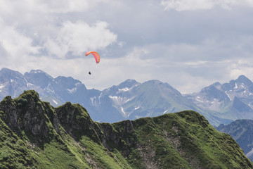 Gleitschirmflieger schwebt über den Alpen