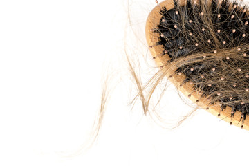 Wood hairbrush on white background. Close-up with long brown hair