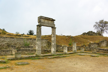 Ancient arch with carved stone portico-the ruins of the ancient Greek city of Panticapaeum on mount Mithridates on a cloudy autumn day