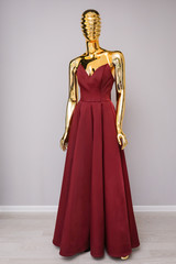 Burgundy dress on gold mannequin