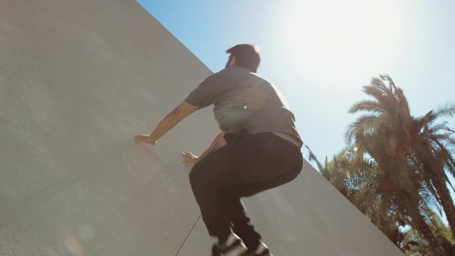 Close up of parkour athlete running up wall doing backflip outside 