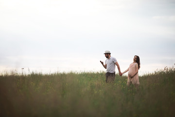 Naklejka premium Couple man and pregnant girl in the field