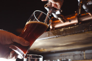bartender pours a dark beer close up