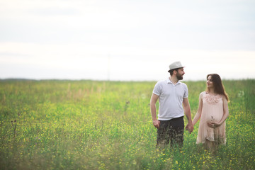 Fototapeta premium Couple man and pregnant girl in the field