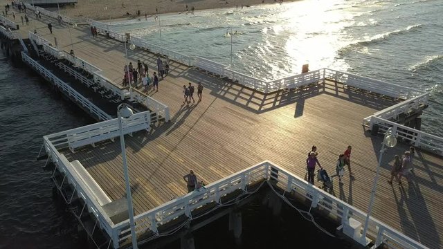 Aerial of People Walking on Wooden Pier in Sopot Poland at Sunset