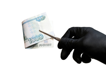 A close-up of a man's hand in a black glove that holds one thousand Russian rubles with tweezers. The concept corruption, violation of the law and the work of a criminalist or a laboratory assistant.