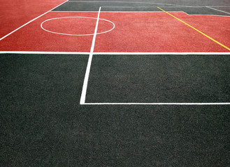 Fototapeta premium Surface of red and black sports field with white lines. Playing ground for games