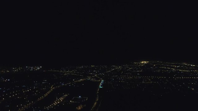 Lightning strikes in the sea over the night city. Aerial view.