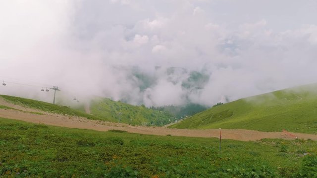 View of mountains with clouds over them, roads and chair lift from viewing platform Rosa Pik