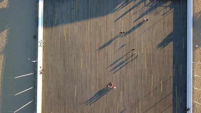 Aerial of People and Shadows Walking on Wooden Pier Top Down