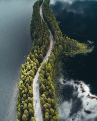 Road on a narrow piece of land between two lakes with forest - 223597123