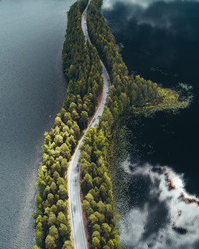 Road on a narrow piece of land between two lakes with forest
