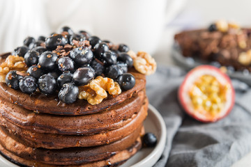 Stack of homemade chocolate pancakes with blueberries and chocol