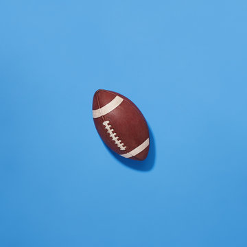 Classic NFL Football Leather Pigskin Worn Football Top Down View on Blue Background
