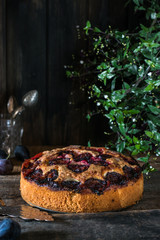 Homemade plum pie on the old wooden background. Vintage spoon. Still life of food. plum tart. Autumn harvest. Old fashion cuisine. Portion of pie. Plum bakery. Rustic open pie.