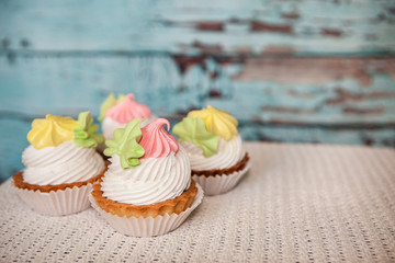 Pink and yellow cupcakes on vintage blue background, colorful sweet food