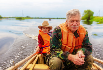 Fototapeta premium grandfather with his grandson on a fishing trip. Copy space for your text