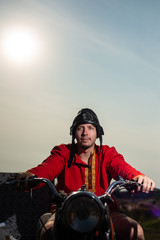 Fototapeta na wymiar Russian motorcyclist on old Soviet motorcycle on sky background
