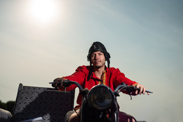 Russian motorcyclist on old Soviet motorcycle on sky background