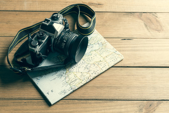 Camera And Map On Wooden Table