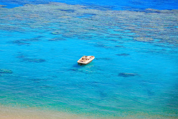 Fototapeta na wymiar beach with coral reef, turquoise sea and boat