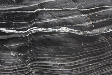 A textured background image of the layers of slate and marble that have been compressed together over millions of years in the cross section of a geological rock formation