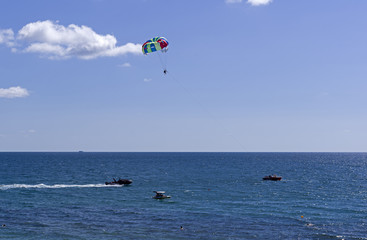 Water attraction - a boat tows a men on a parachute over the sea.