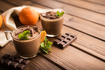 chocolate mousse dessert with orange on rustic wooden background.