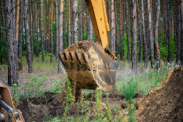 Excavator performs excavation work by digging the ground with a bucket © Vladimir