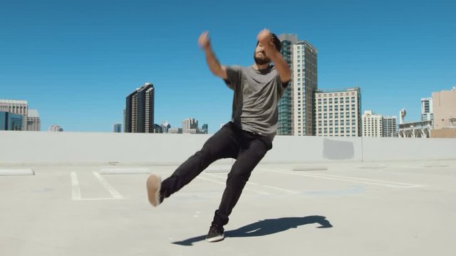 Slow motion of a man flipping on a rooftop