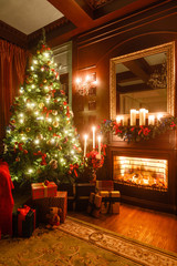 gifts at the Christmas tree. Christmas evening by candlelight. classic apartments with a fireplace.