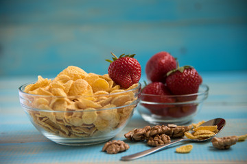 Tasty cornflakes with walnut in glass bowl