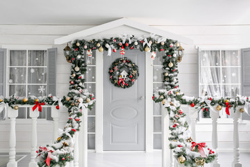 Christmas morning. porch a small house with a decorated door with a Christmas wreath. Winter fairy...