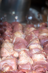 Raw meat on skewers on the grill .