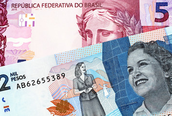 A blue, two thousand Colombian peso bank note with a purple five Brazilian reais note