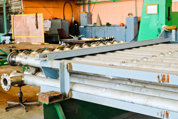 Warehouse, storage of metal iron long stainless pipes with flanges, passages and branches at the...