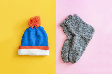 top flat lay of winter travel set with wool hat and socks creative on pink and yellow background f
