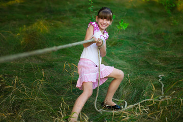 Sporty girl in tug of war competition in summer vacations