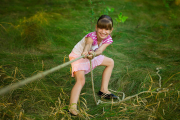 Sporty girl in tug of war competition in summer vacations