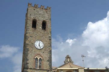 Fototapeta na wymiar Vecchia torre con l'orologio di una piccola chiesa di un piccolo paese su una di una scogliera italiana.