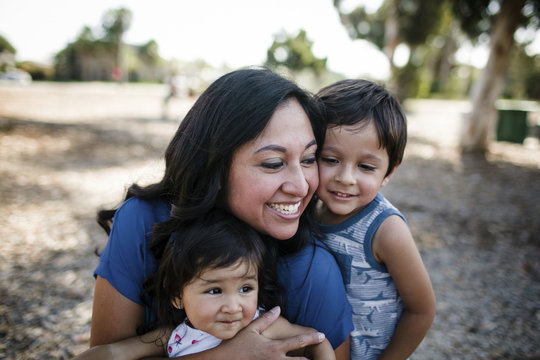 Happy Mother Playing With Children At Park