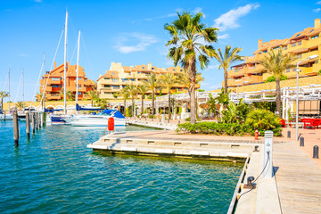 Sailing Boats in beautiful Sotogrande marina with colorful apartments and palm trees on shore, Costa del Sol, Spain
