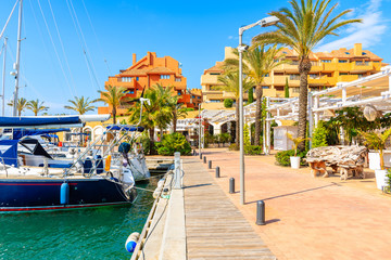 Sailing boats anchoring in Sotogrande marina with colorful houses, Andalusia, Spain