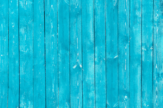 Light blue old wooden background of boards. Old, worn, cracked paint. Bright saturated color.