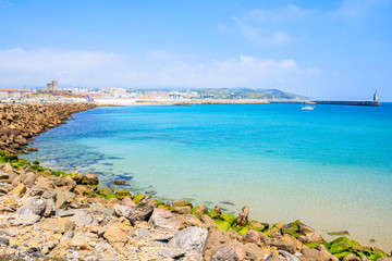 Rocks on sea coast and view of beach in Tarifa town, Costa de la Luz, Spain
