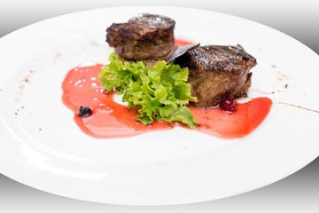 fried beef steaks with spices, on a gray table
