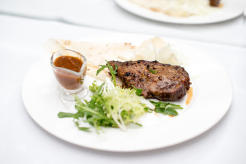 fried beef steaks with spices, on a white table